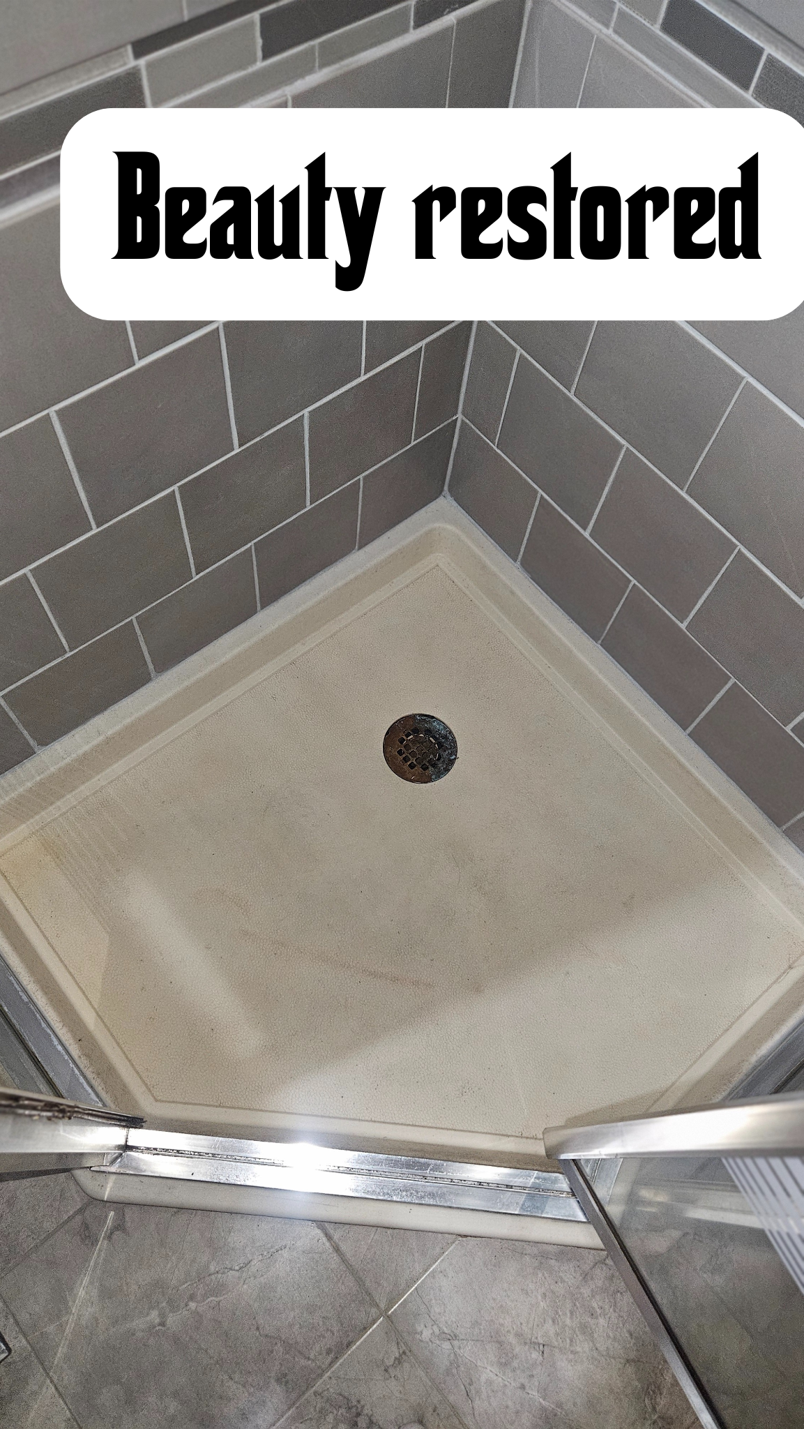 A shower corner with gray tiled walls and a beige shower base with a drain. The text 'Beauty restored' is overlaid on the image.