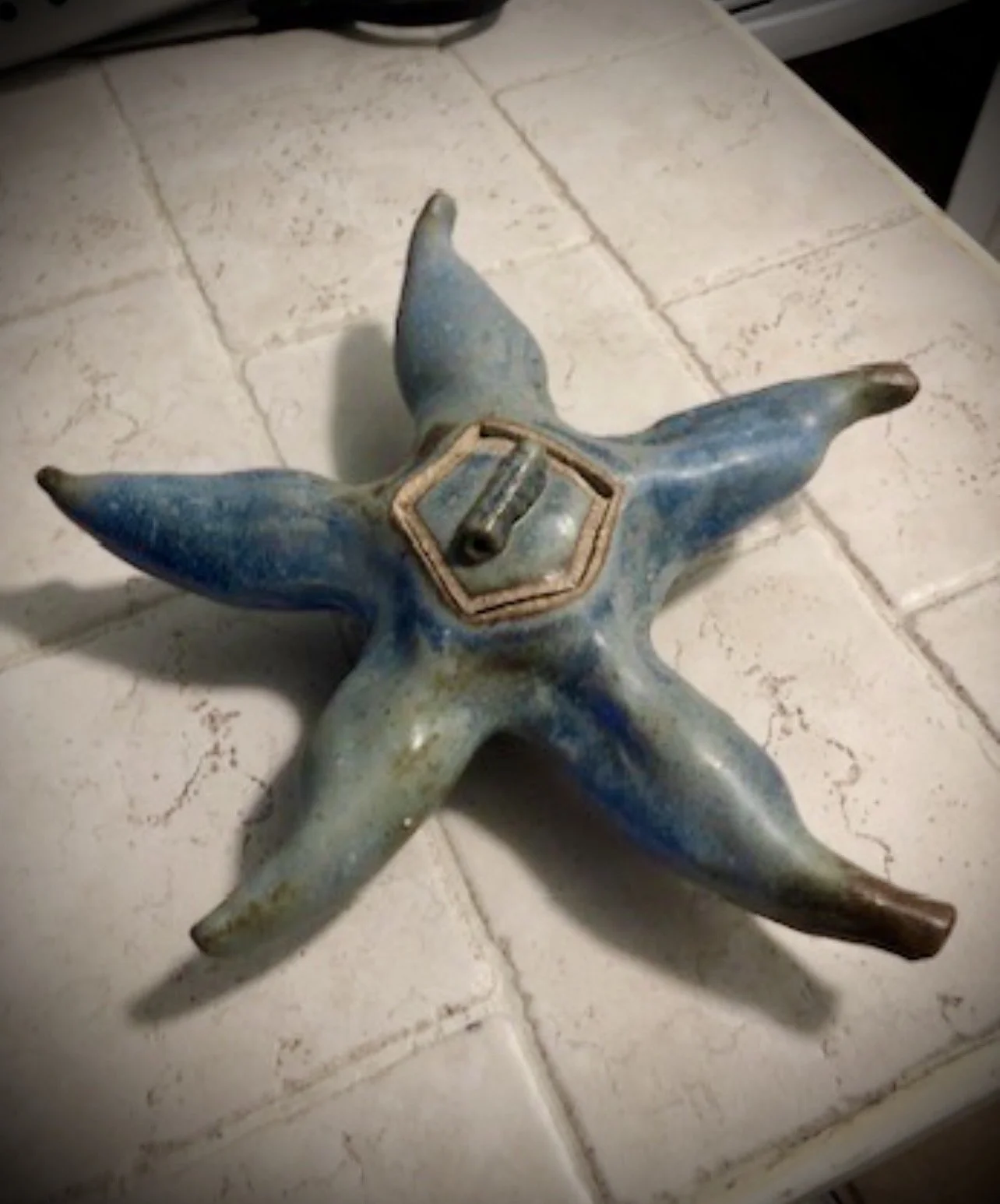 A ceramic starfish-shaped dish with matching lid.