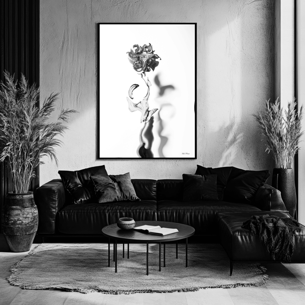 A modern black leather couch with pillows, a round coffee table with a book and bowl, tall potted plants on each side, and a large abstract black-and-white portrait on the wall in a contemporary living room.