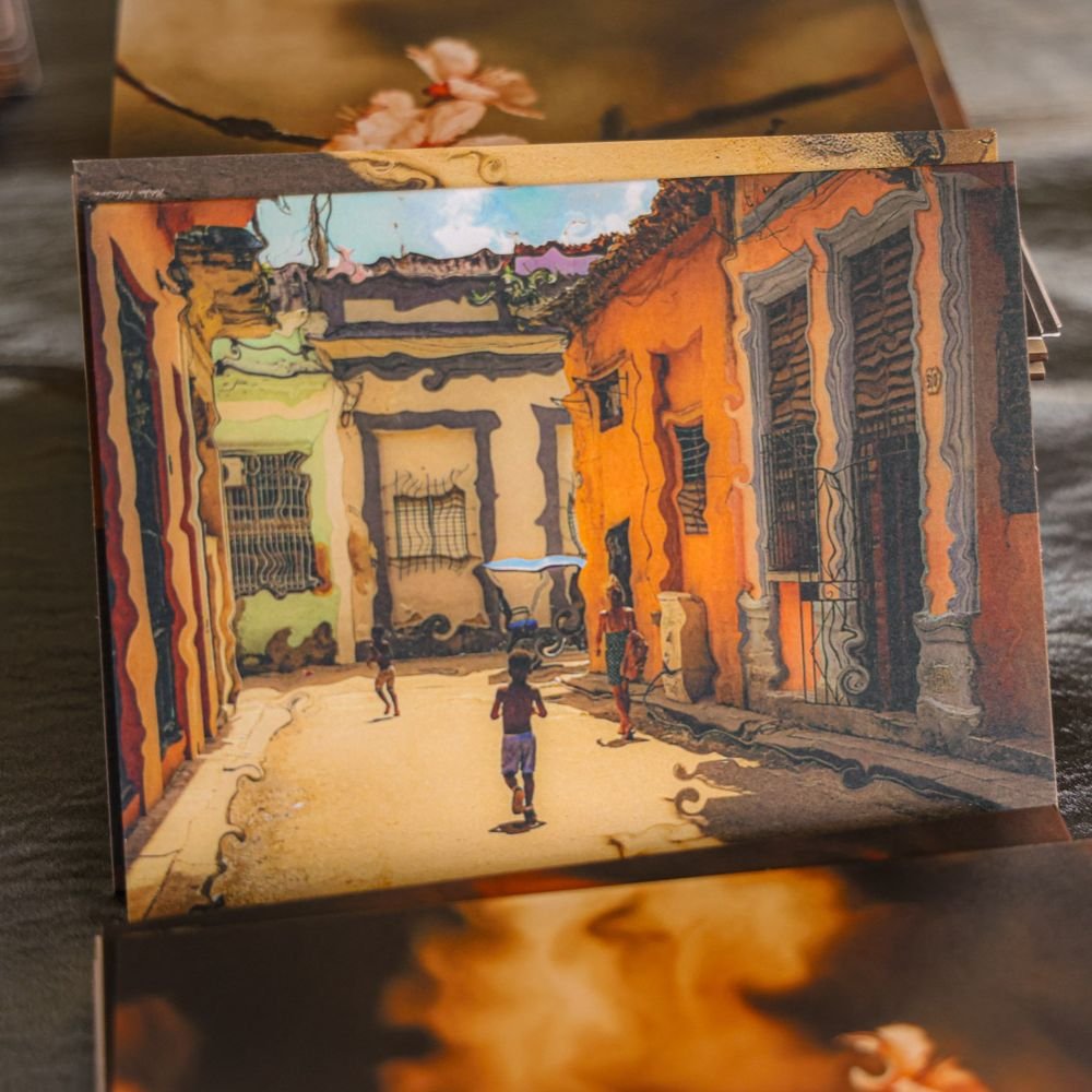 A photograph of a colorful artwork showing a street scene with children playing, surrounded by vibrant orange and green buildings with iron barred windows, painted in a distorted, impressionistic style.