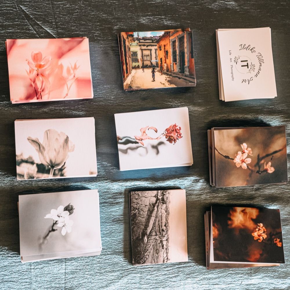 Various photo cards featuring flowers, city scenes, and landscapes arranged on a dark wooden surface.