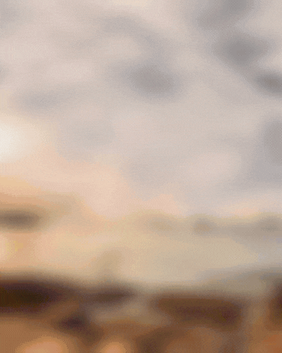 A cloudy sky over a distant landscape with some land and possible water in the foreground.