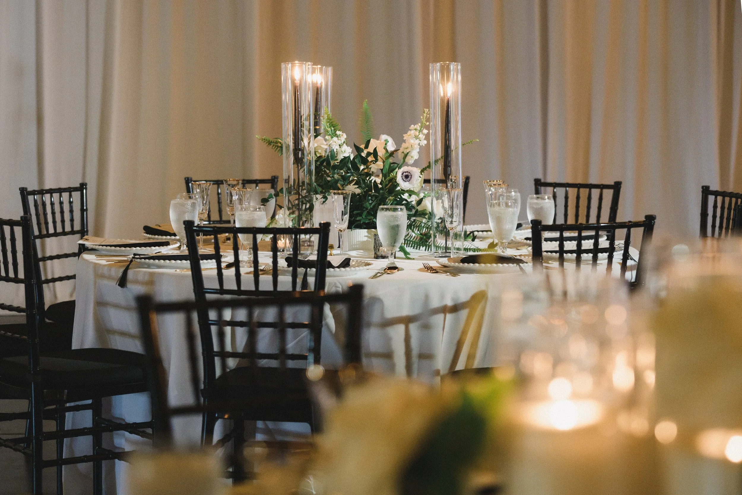 Table decorated with floral centerpiece and candles at an event or celebration.