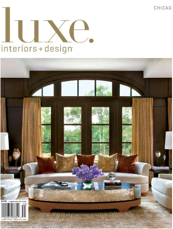 Cover of Luxe Interiors & Design magazine featuring a living room with large window, gold curtains, and a white sofa with decorative pillows.