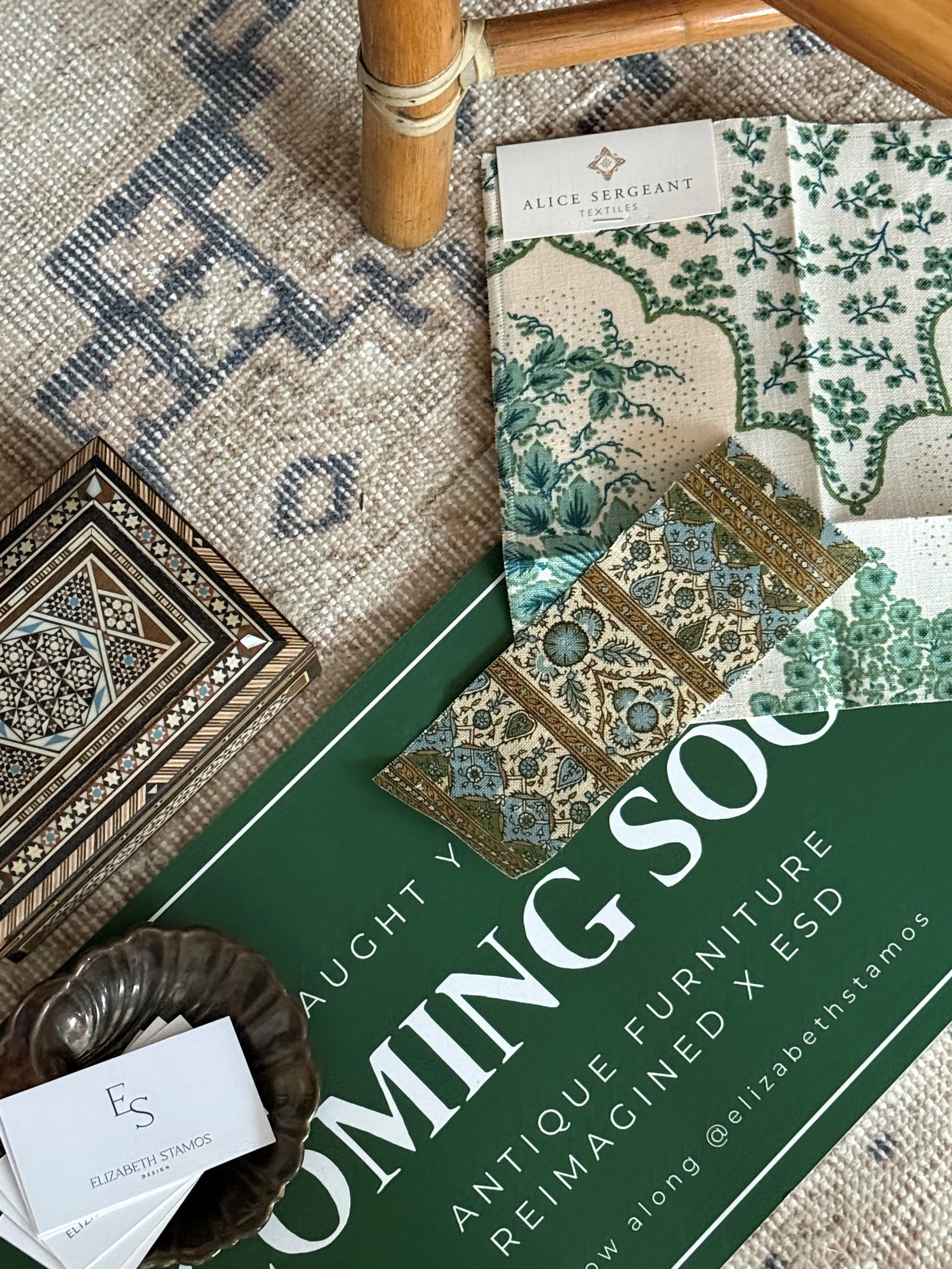 Display of fabric samples on a rug, with a large green book titled 'DOWNTIMING' and a decorative card in the image.