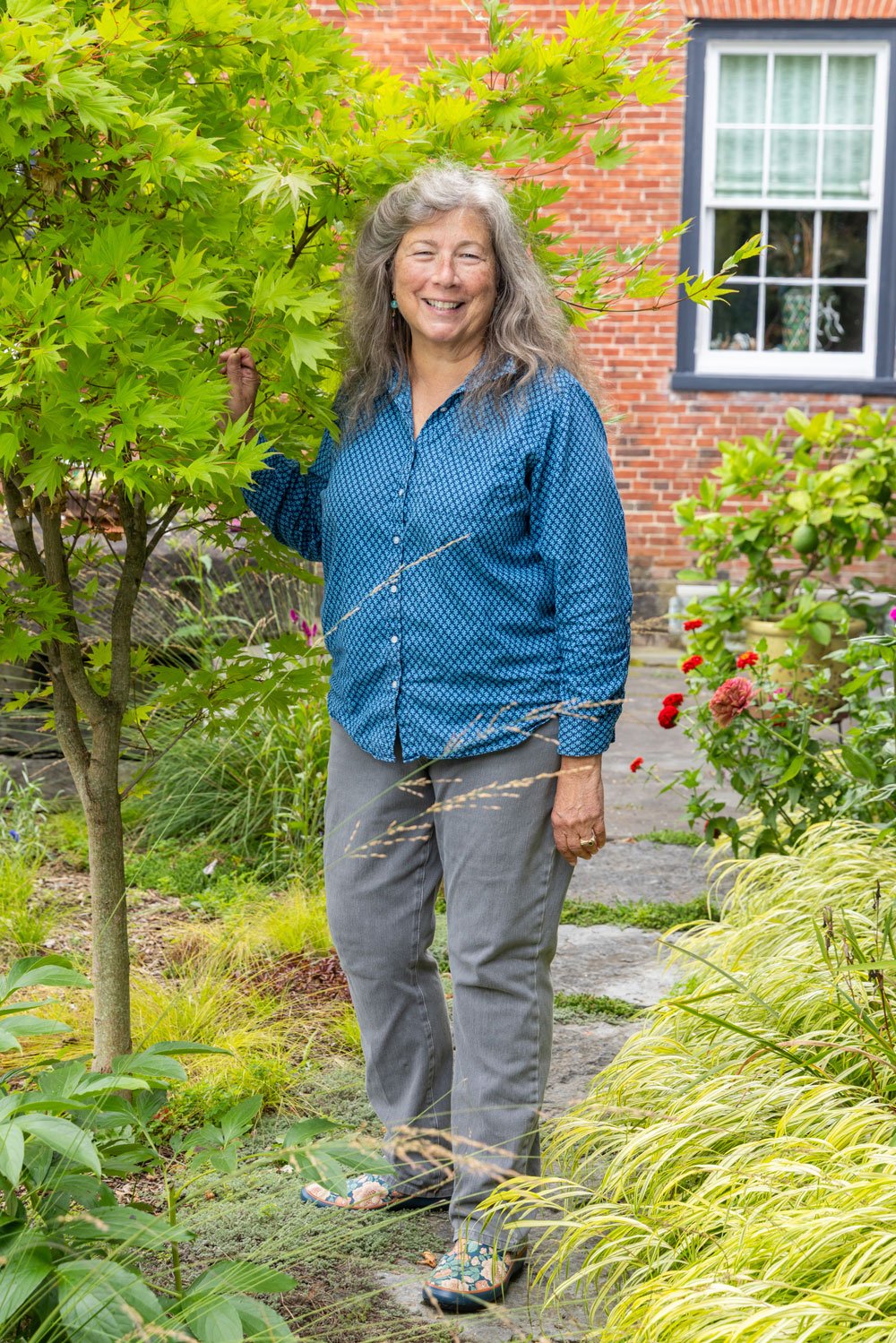 Tina Perrelli standing next to tree smiling