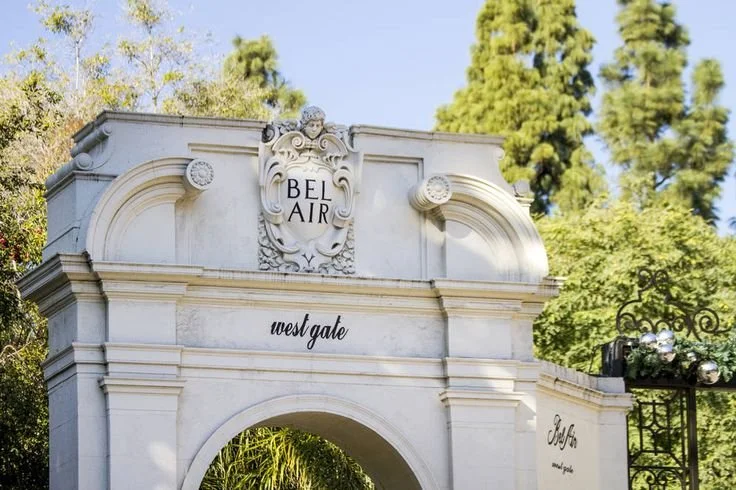 Entrance archway with ornate design and the word "BEL AIR" at the top, labeled as "west gate," surrounded by trees and greenery.