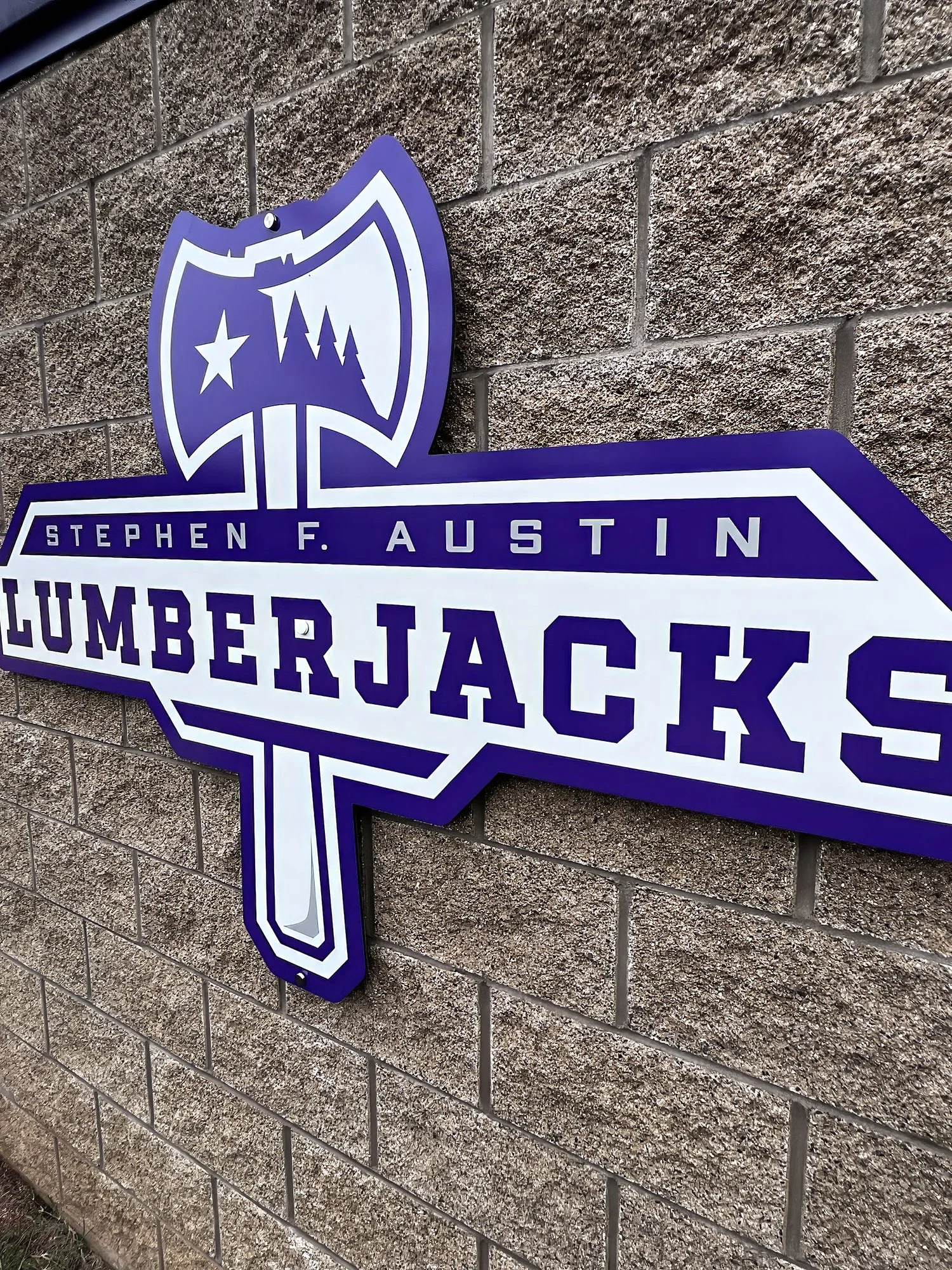 Stephen F. Austin University Lumberjacks logo sign mounted on an exterior brick wall — custom dimensional lettering designed and installed by SI Design Facility Branding.