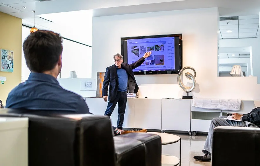 Alan Burks pointing at screen while presenting to a group