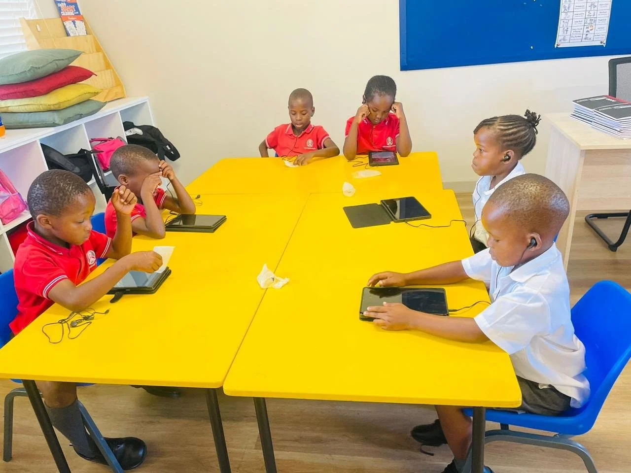 Schülerinnen und Schüler lernen mit einem Tablet im Imizamo Yethu Learning Hub.