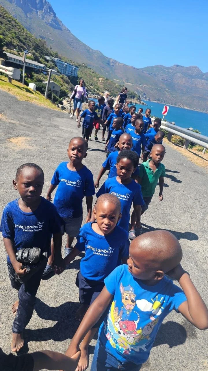 Kinder vom Kindergarten Little Lambs in Kapstadt gehen in einer Kollone zum Schulausflug.