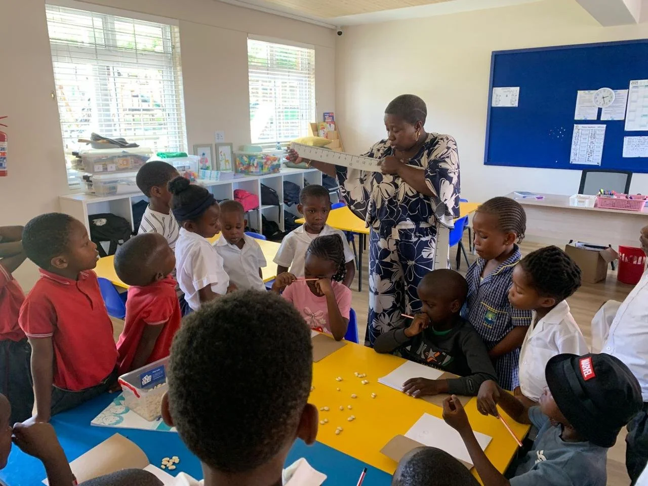 Schülerinnen und Schüler lernen mit ihrer Lehrerin rechnen im Imizamo Yethu Learning Hub.
