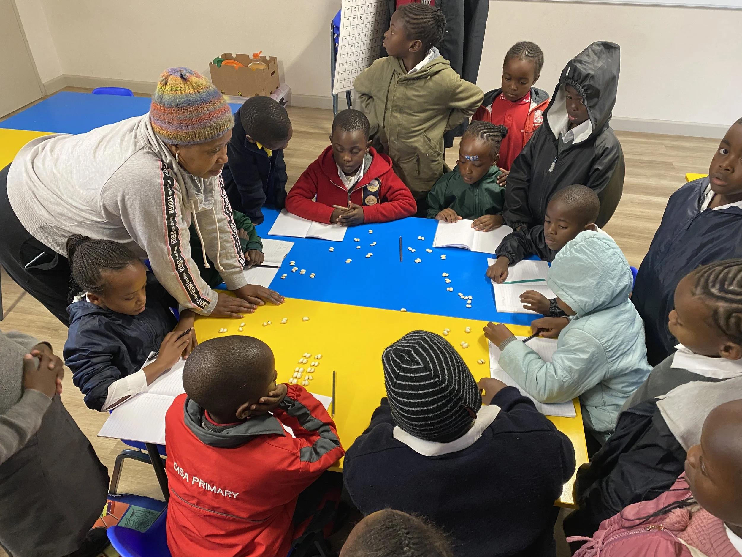 Schlüerinnen und Schüler lernen mit der Lehrerin Mathematik im Imizamo Yethu Learning Hub.