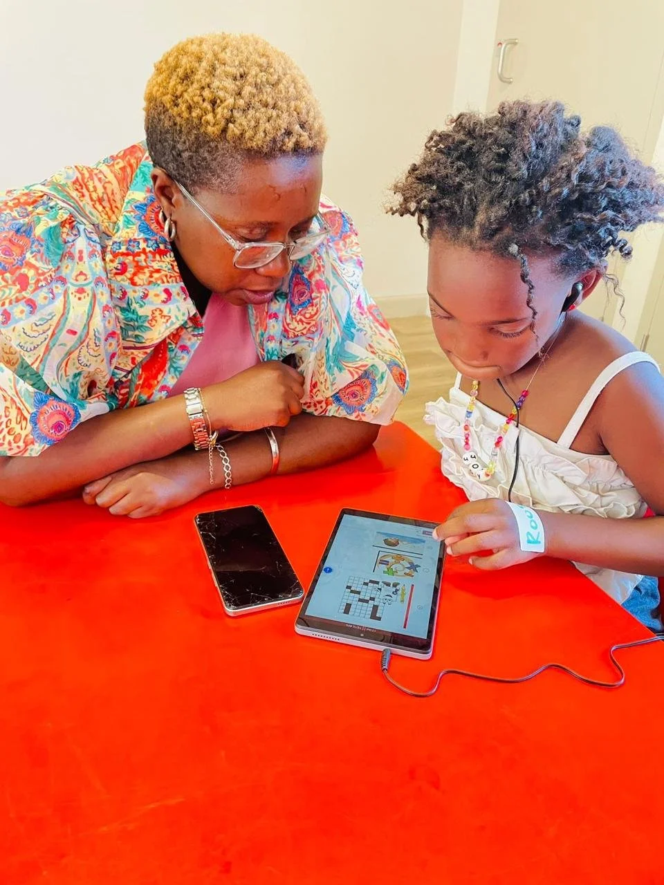 Eine Lehrerin und eine Schülerin lernen gemeinsam auf einem Tablet.