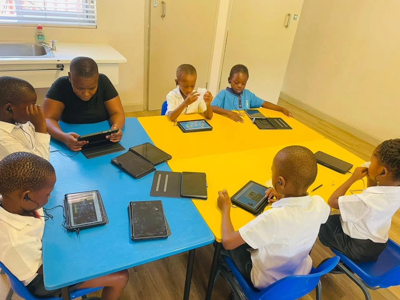 Schülerinnen und Schüler lernen auf Tablets im Imizamo Yethu Learning Hub in Kapstadt.