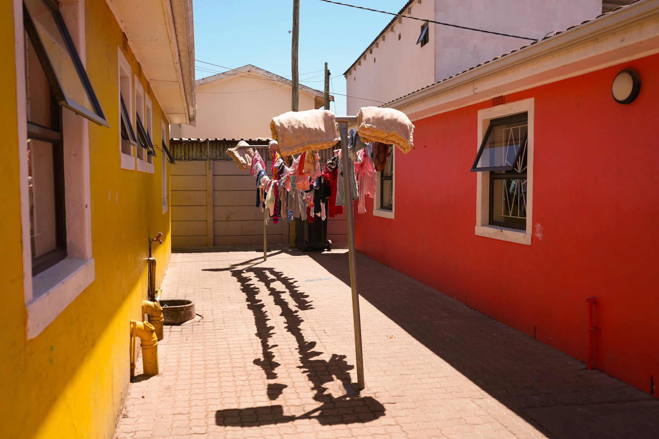 Wäscheleine von Babykleidern in Baphumelele einem Sozialprojekt in Khayelitsha.