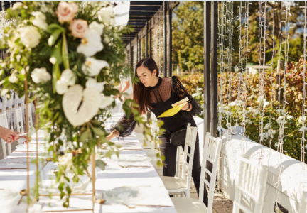 Woman decorating a table with flowers outdoors