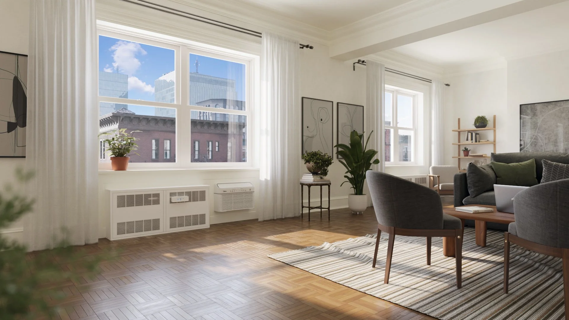 A view of a living room with a recessed convector radiator underneath large windows. There is a through wall heat pump next to it. There is a small device attached to the radiator.