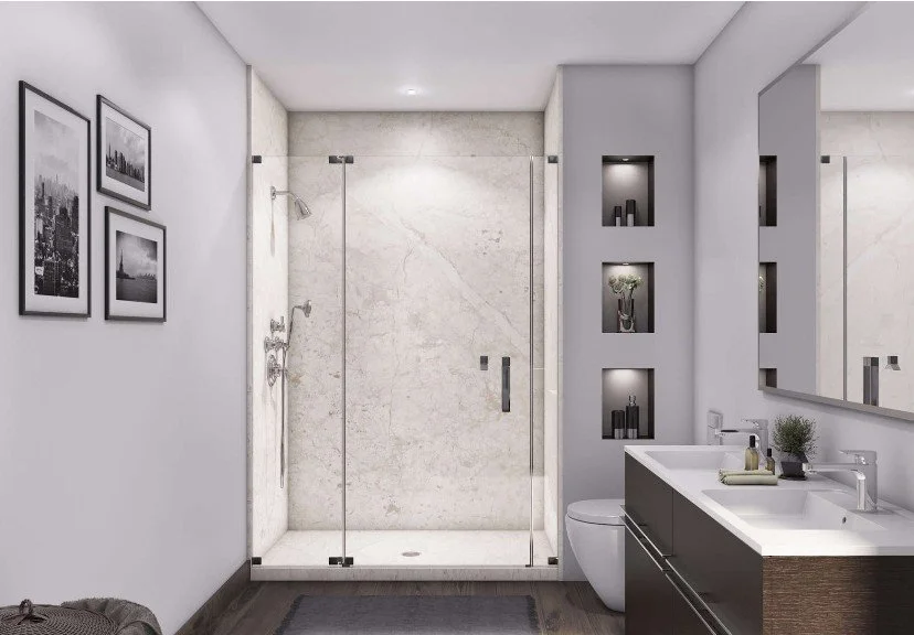 Modern bathroom with glass shower enclosure, white and gray walls, framed black-and-white cityscape photos, and a white vanity with dual sinks and a mirror.