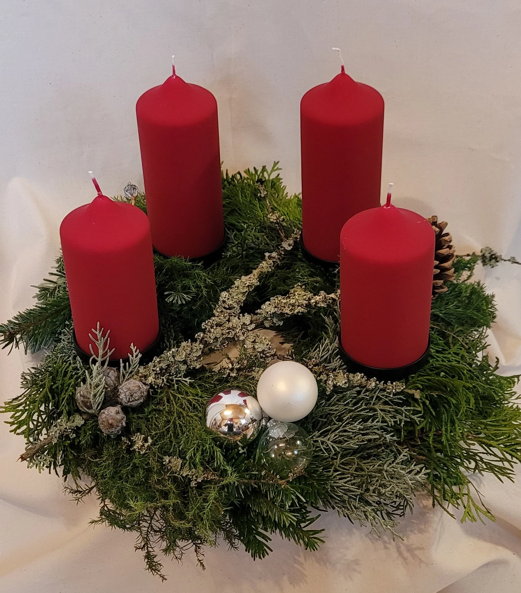 gebundener Naturkranz aus verschiedenen Materialien mit hochwertigen, echten Kerzen in Samtlack