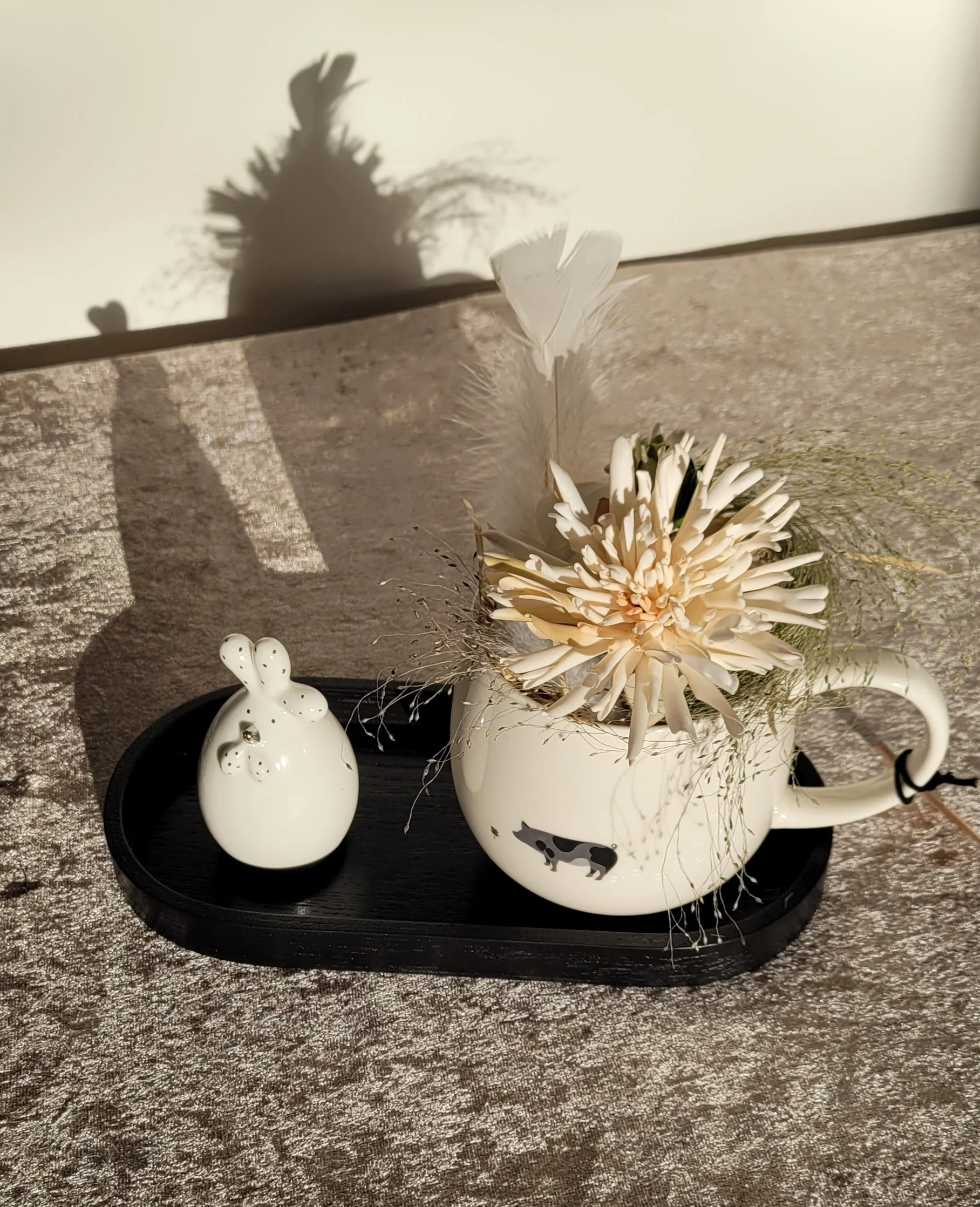 Porzellanhuhn mit dekorierter "Footprint-Tasse" auf Holztablett