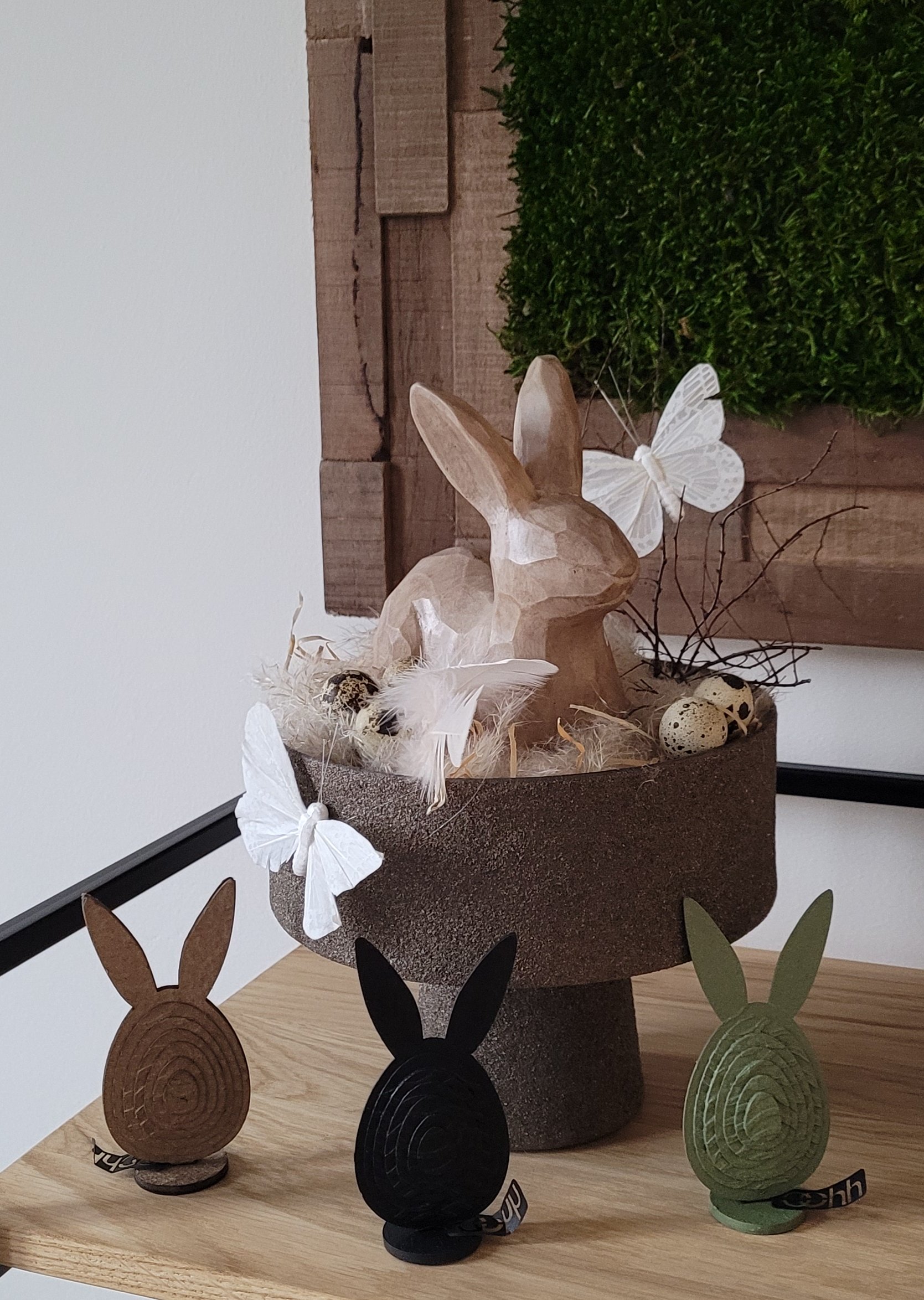 Holz-Osterhase in einer Schale aus recyceltem Papier und Holzstaub, dekoriert mit Naturmaterialien und 3 "Osterhasen", hergestellt aus natürlichen Materialien
