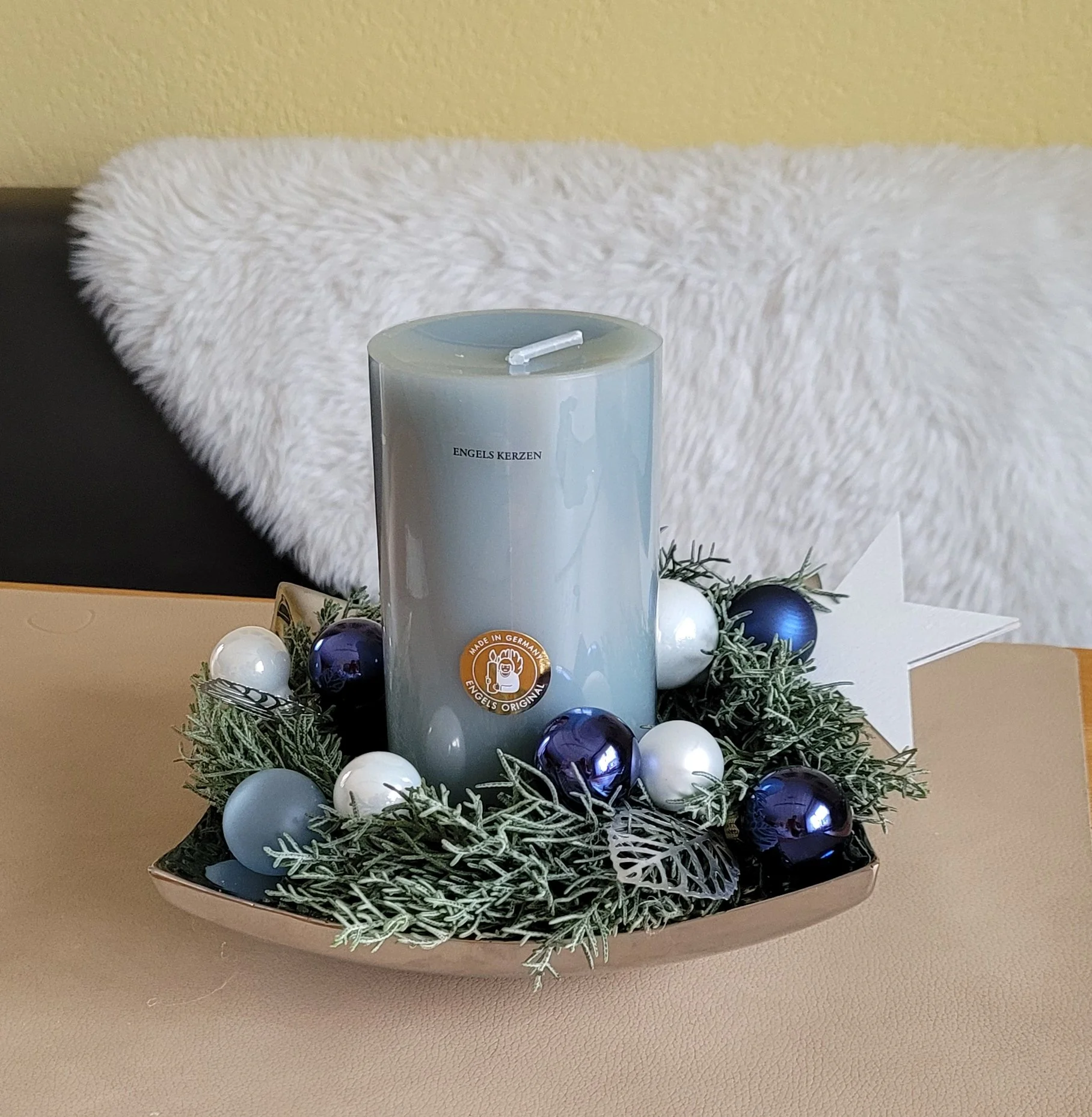 edle, durchgefärbte echte Kerze arrangiert auf hochwertigem Metallteller