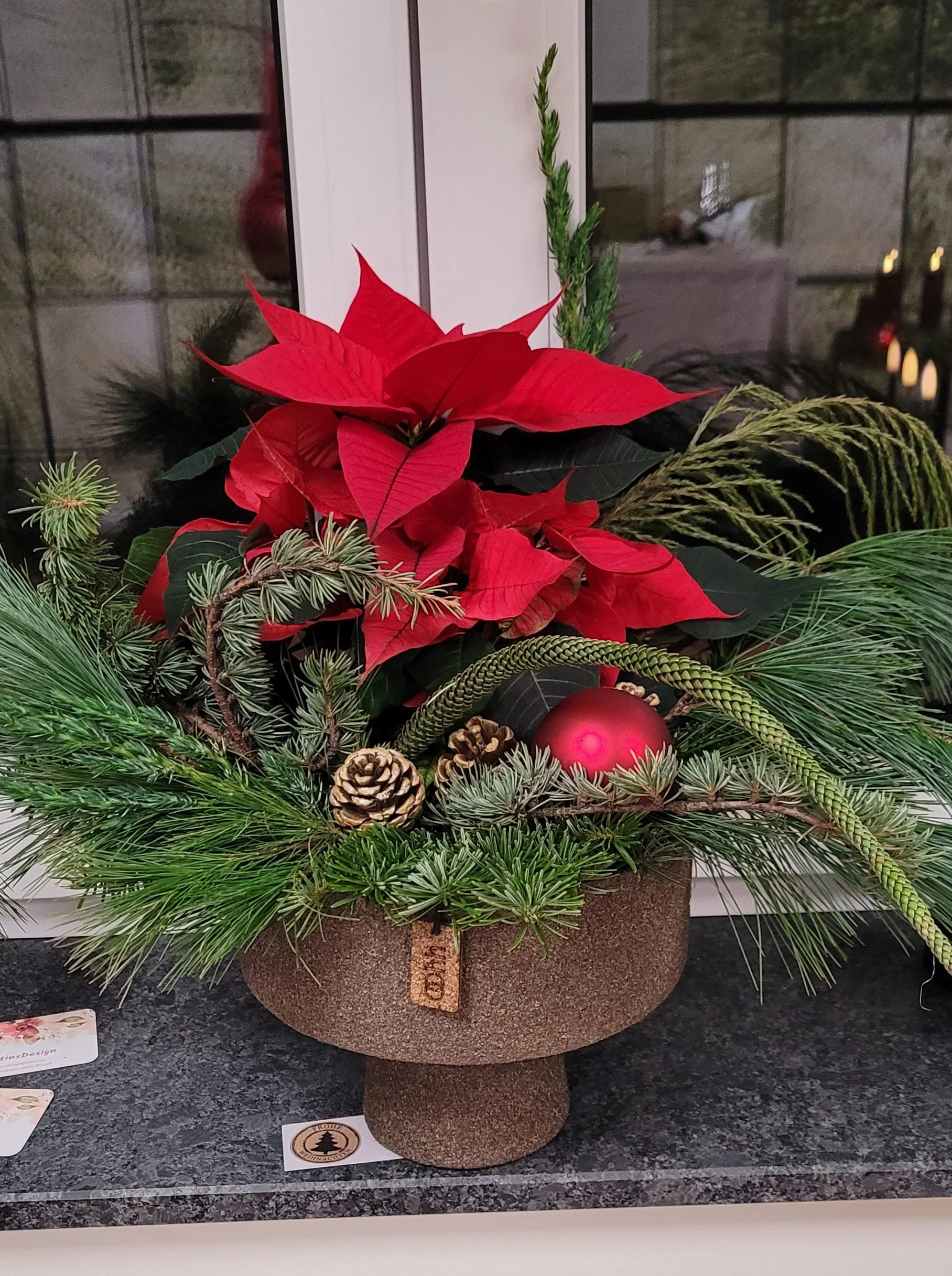 Weihnachtsstern in einer Schale mit Fuß aus recyceltem Papier mit Holzstaub, wasserdicht durch Naturlatex, dekoriert mit verschiedenen Naturzweigen