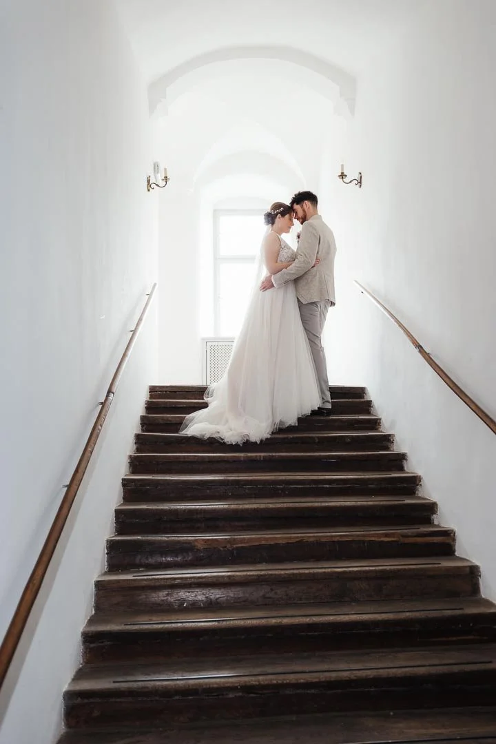 Elegantes Hochzeitsfoto eines Paares auf einer Treppe im Schloss Neuburg an der Kammel bei Günzburg