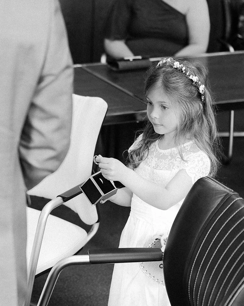 Tochter des Hochzeitspaares übergibt dem Paar die Eheringe bei der standesamtlichen Hochzeit in den Stauden bei Augsburg