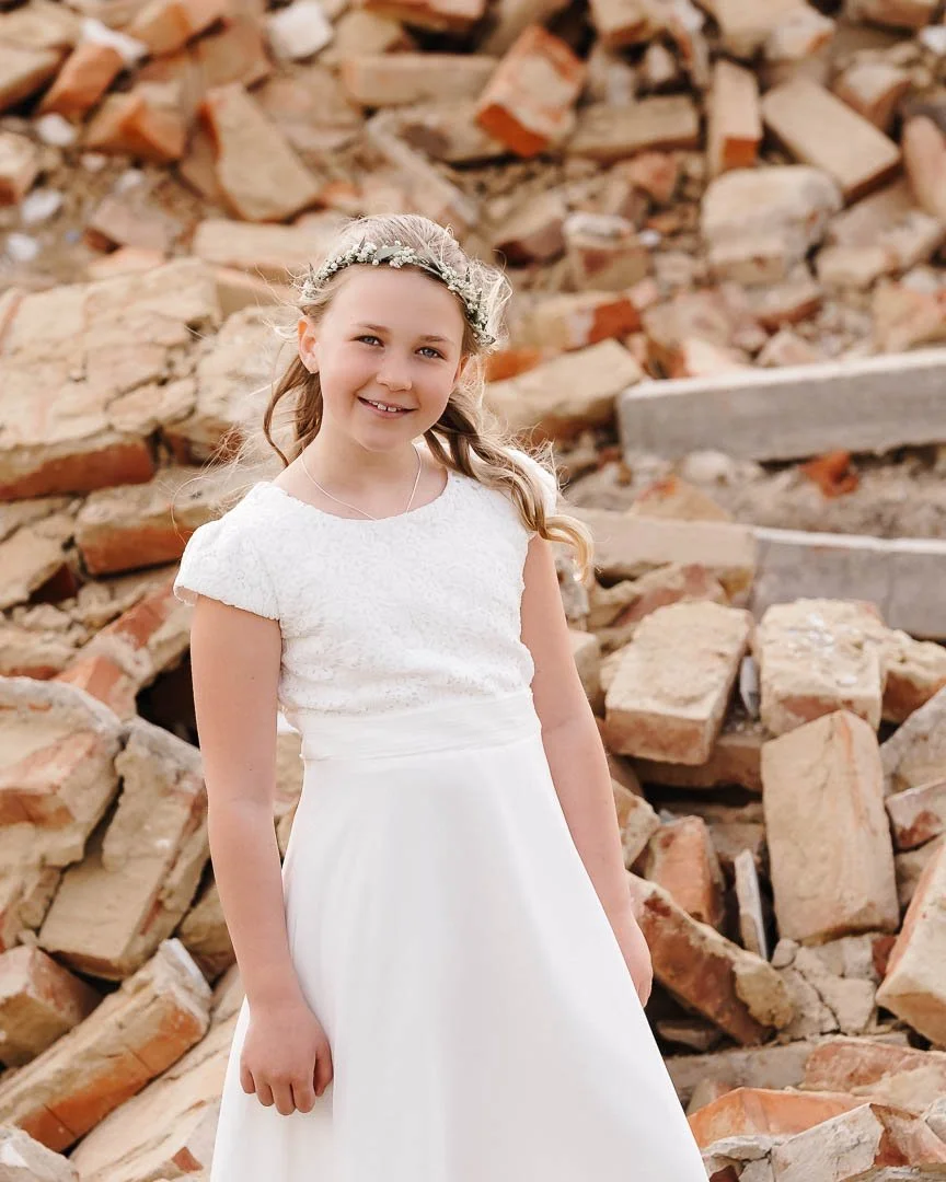 Portraitfoto eines Mädchens in einem schicken, weißen Kleid vor einem verfallenen Haus im Landkreis Günzburg