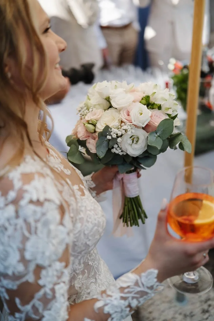 Das Bild zeigt den Brautstrauß und den Drink, den eine deutsche Braut auf ihrer Hochzeit in Italien in den Händen hält