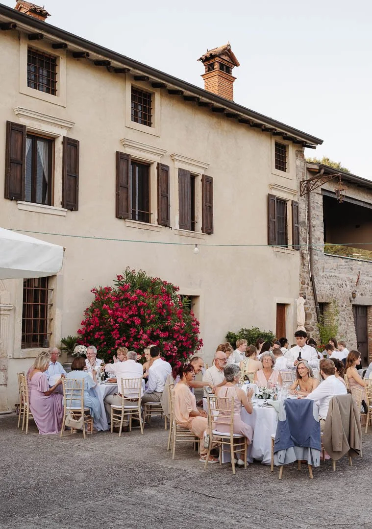 Foto einer Hochzeitsfeier in der günstigen Location Corte Marzago am Gardasee, auf dem die Hochzeitsgesellschaft im Außenbereich beim Dinner zu sehen ist