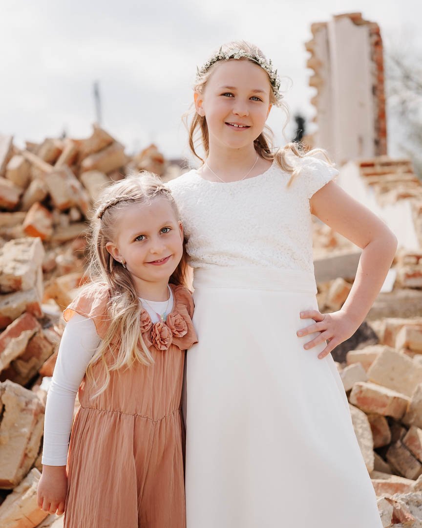 Portaitfoto von zwei Geschwisterkindern vor einer Ziegelhaus-Ruine nach der Kommunion im Landkreis Günzburg
