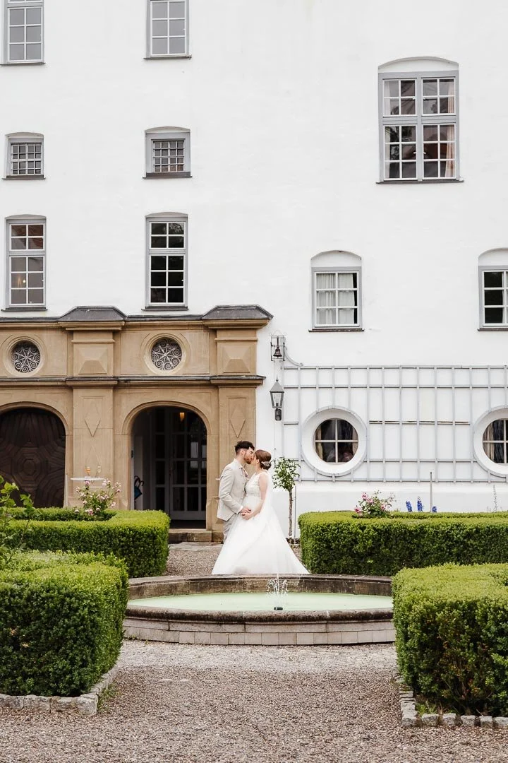 klassisches Hochzeitsfoto eines Paares vor dem Schloss Neuburg am Brunnen im Innenhof