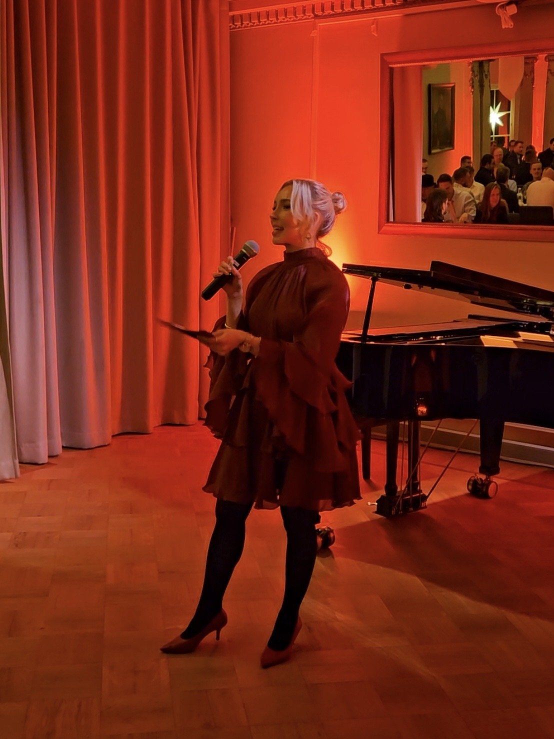 Katariina Kinnunen juontamassa tyylikästä iltatilaisuutta.