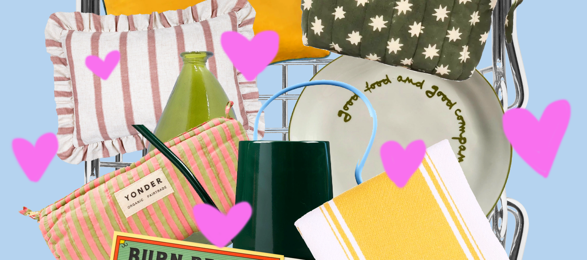 Close-up of a shopping cart filled with colorful home decor items and tableware, including striped and patterned pillows, a green glass bottle, a yellow dish towel, a white plate with green text, and a black and green cup, with pink heart overlays on a light blue background.