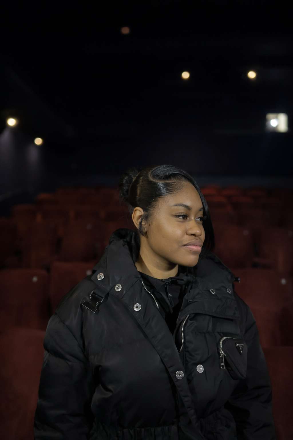 Woman in Prada jacket at theatre.png