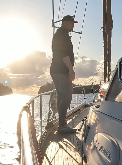 Craig Maggio on the bow of S/V Kleos at sunrise