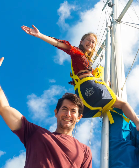 Bryony up the mast of S/V Rhythm with Tony below