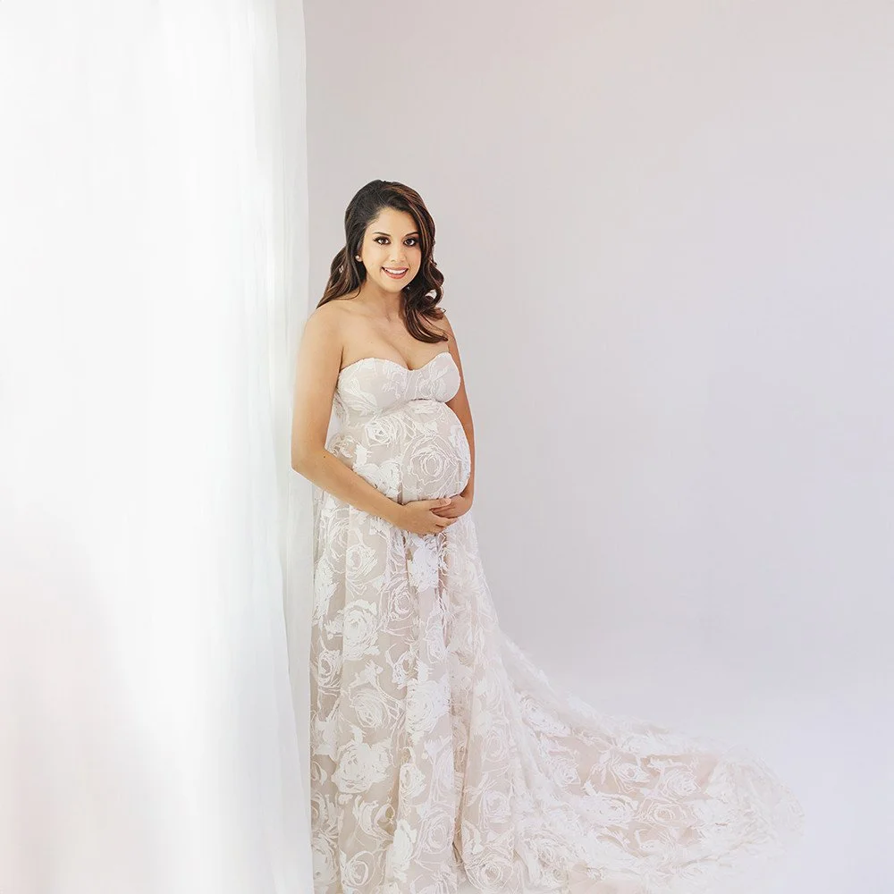 Of all the images I took of this gorgeous mama-to-be, this one stopped me in my tracks. 🌹✨⁠
⁠
There she is, standing by the window in that ethereal white dress with the delicate rose pattern, looking like she just walked out of a dream. The light wr