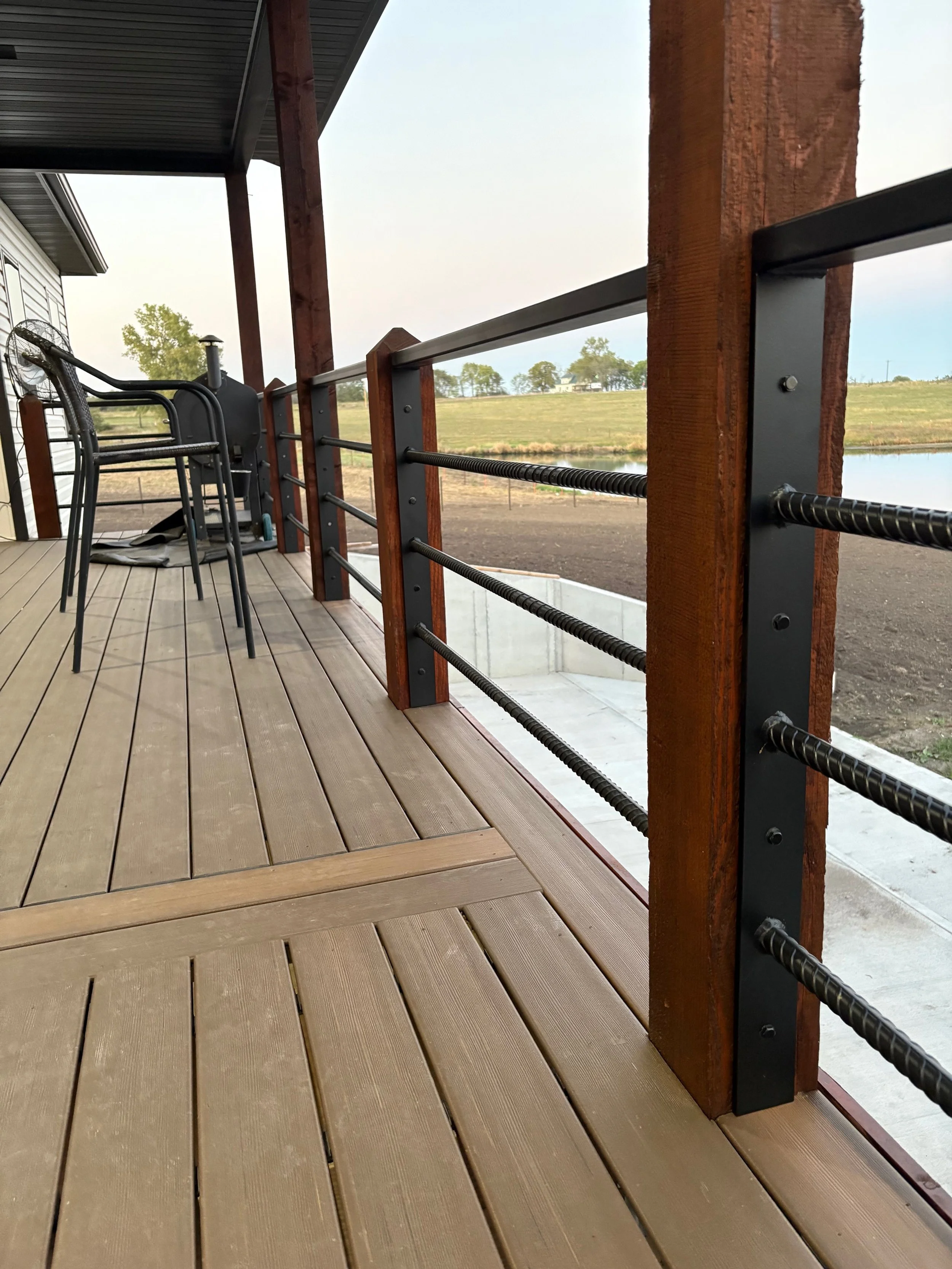 Custom metal railing made of metal rod painted black, fabricated and welded with strong, quality welds to create custom handrails.