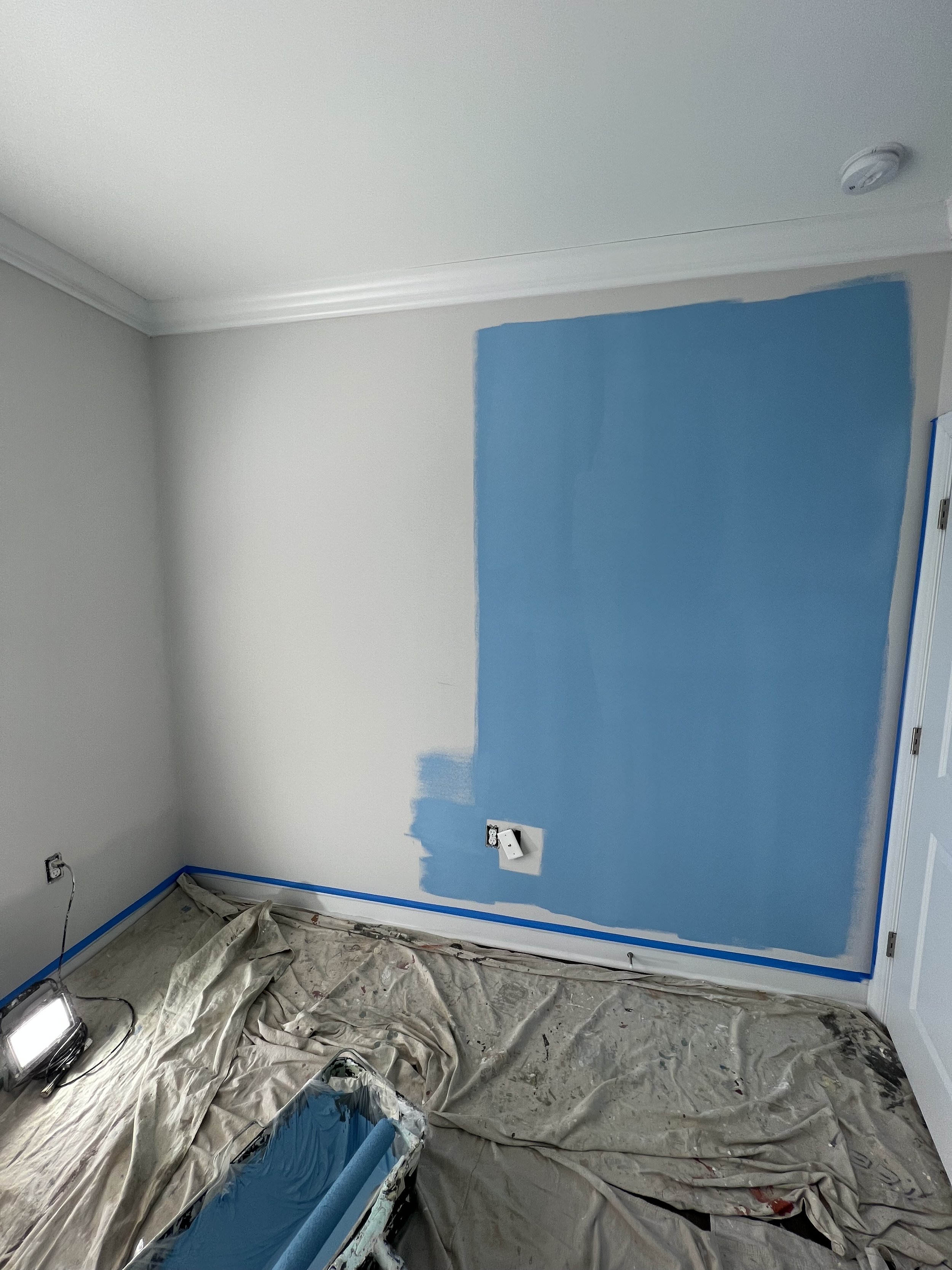 Custom bedroom color transformation featuring rich blue walls, crisp white trim, and a smooth, refined finish