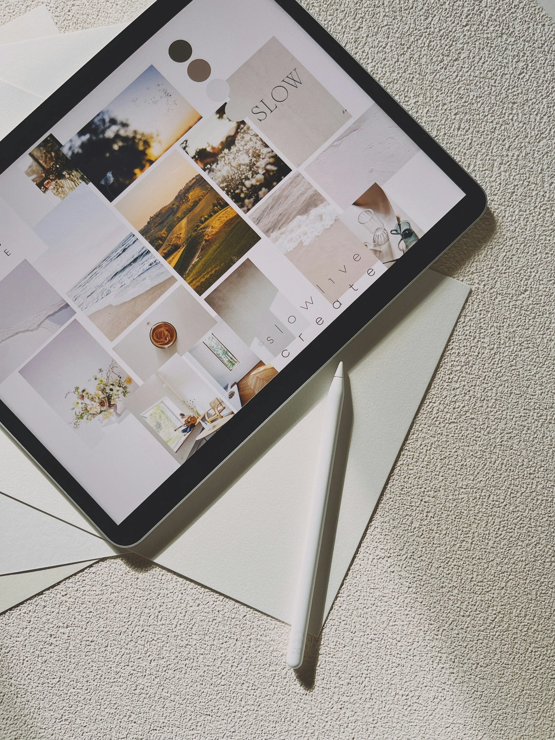 Airbnb example - Digital tablet with a white stylus on a textured surface, displaying a collage of nature and home photos.