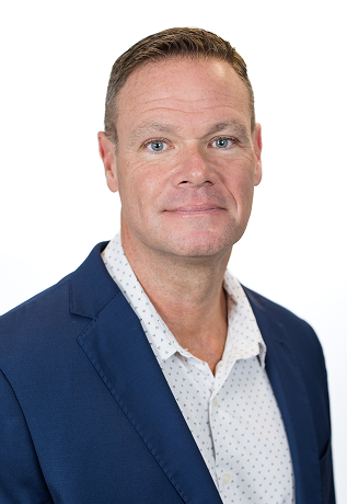 Professional headshot of a man wearing a blue blazer and white shirt with small polka dots, smiling slightly.
