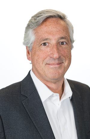 Portrait of a middle-aged man with gray hair, wearing a white shirt and dark suit, against a white background.