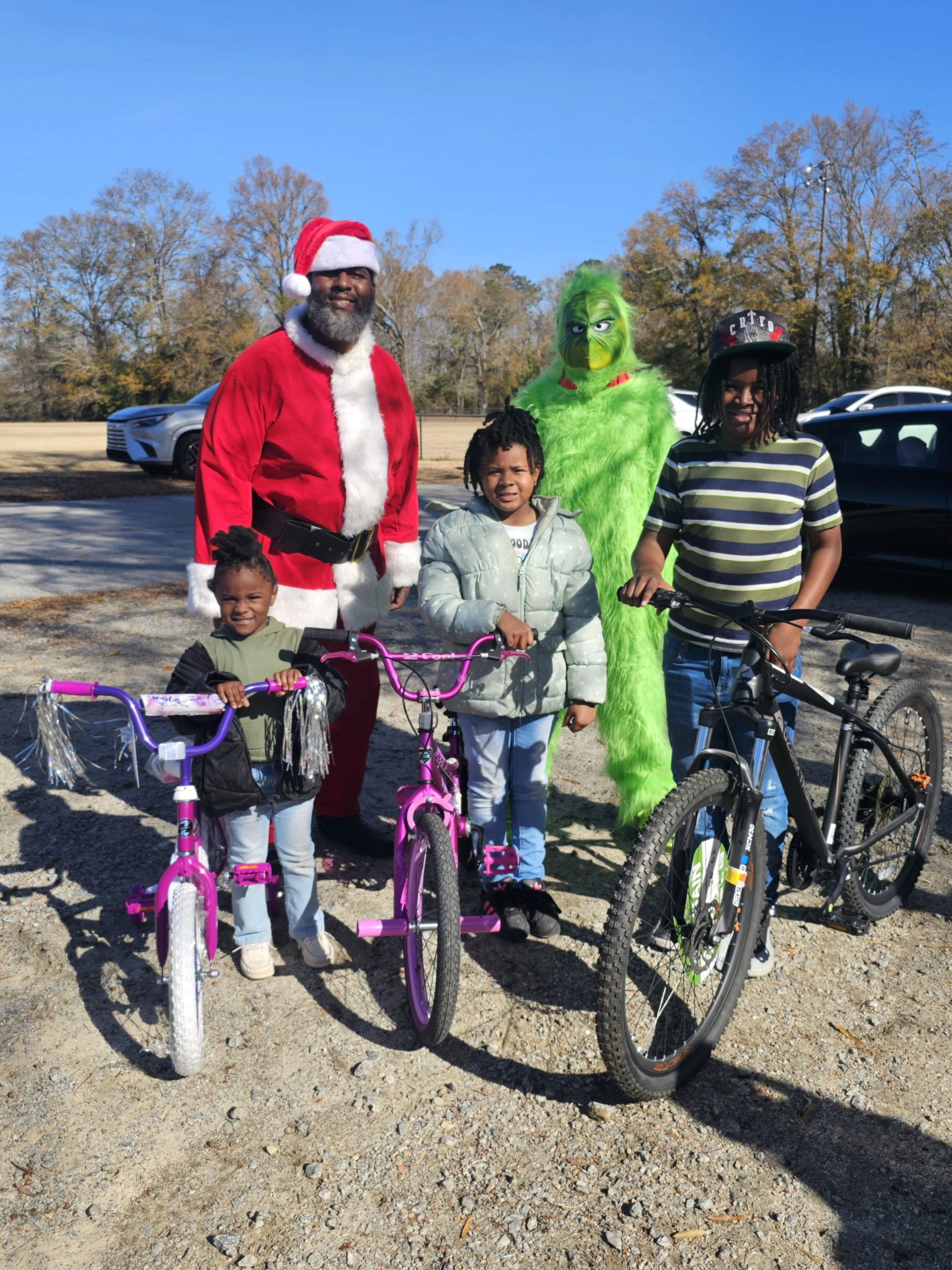 kids on bikes posing with santa and the grinch