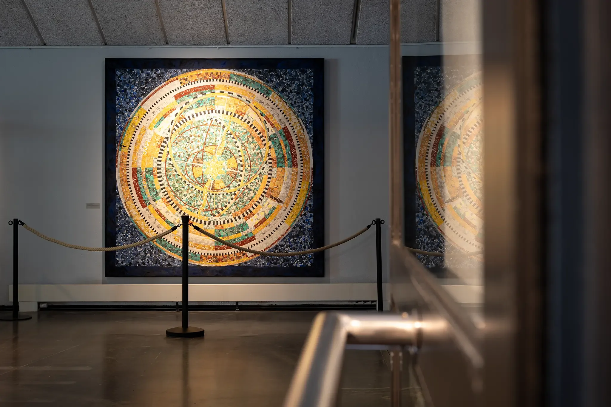 Blick durch den Ausstellungsraum auf ein großformatiges Kunstwerk aus Papier von John Gerard im Papiermuseum Alte Dombach.