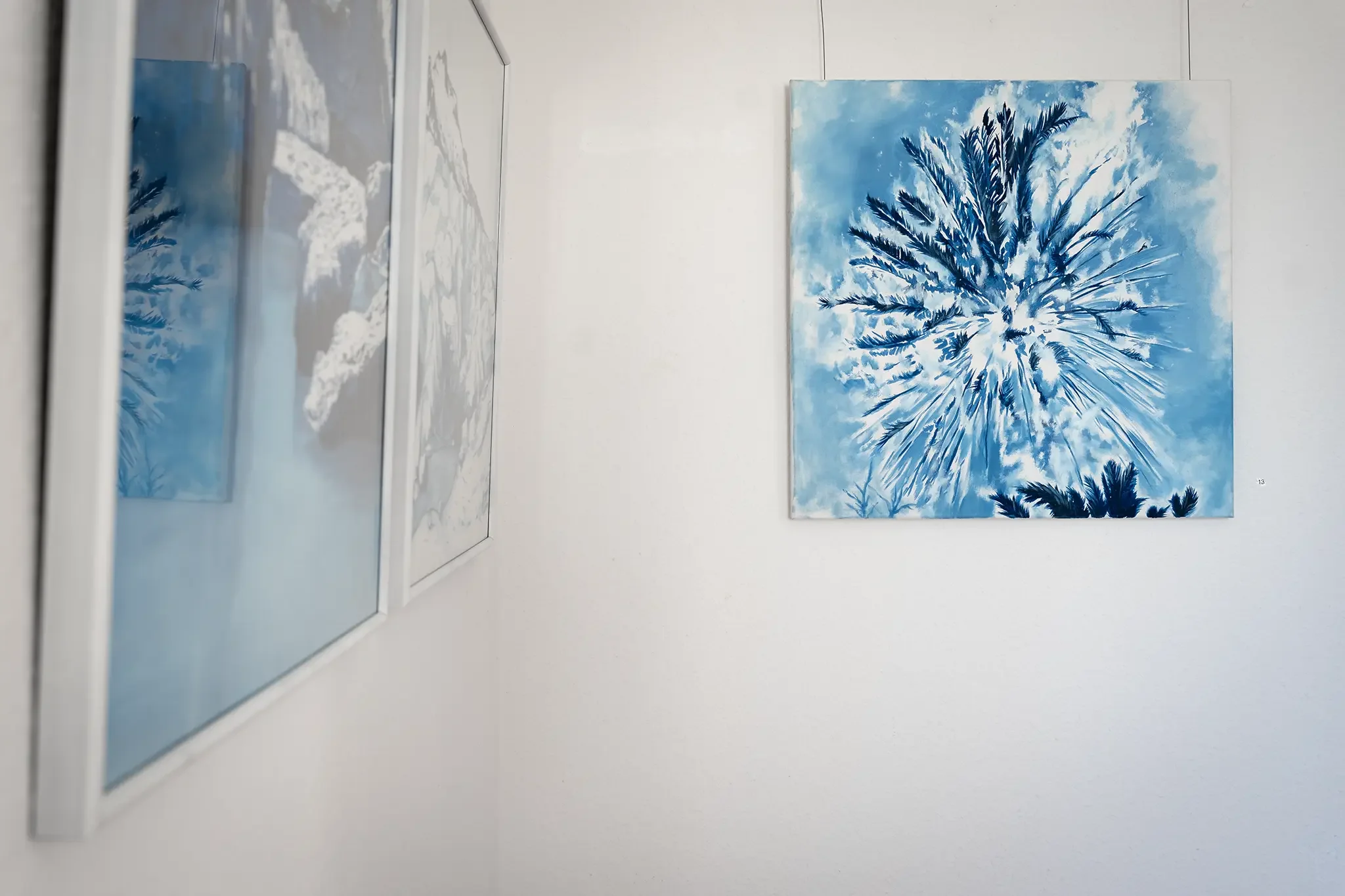Gemälde von Jovita Majewski mit Spiegelung eines weiteren Werkes in der Ausstellung „Blaue Horizonte“