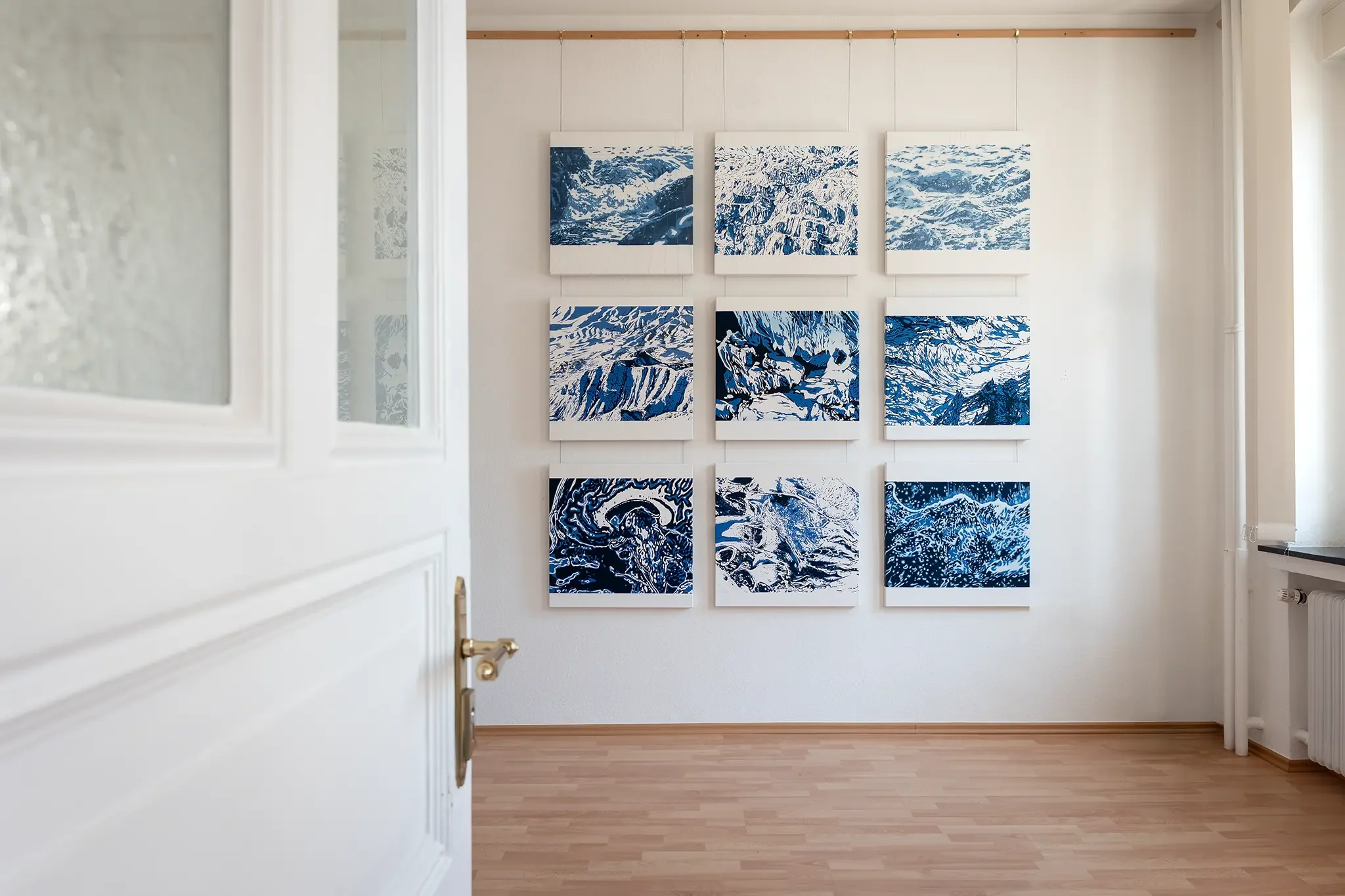 Blick durch eine Tür auf die Ausstellung „Blaue Horizonte“ von Jovita Majewski im Partout Kunstkabinett in Bergisch Gladbach